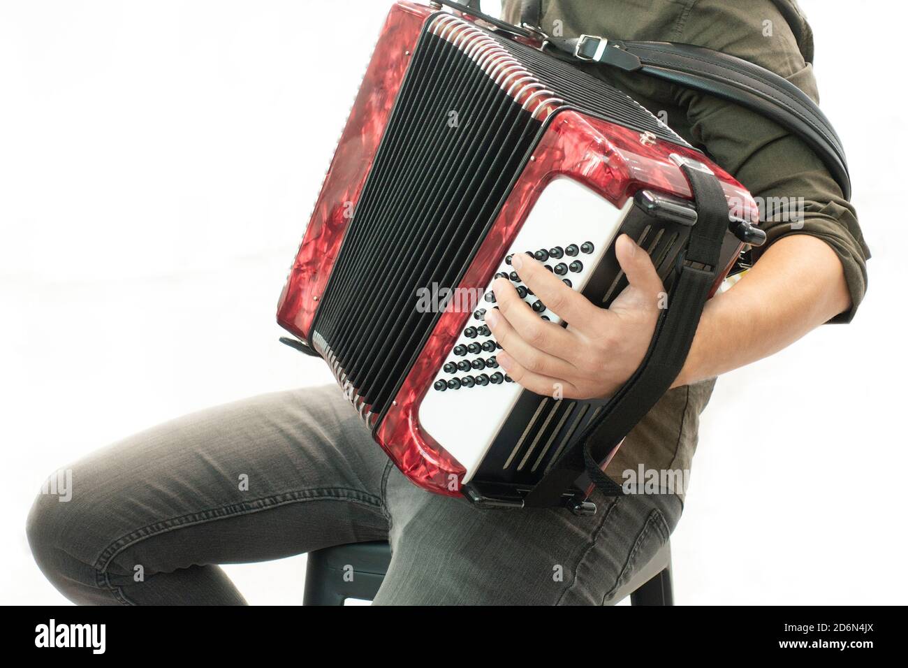 Closeup detail of a man in a black shirt playing the red accordion Hand close-up Stock Photo