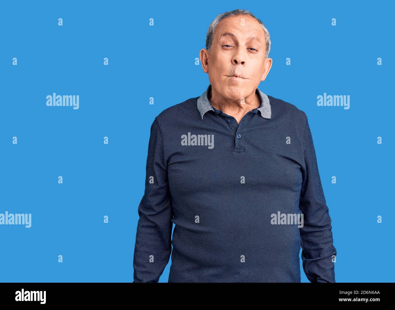 Senior handsome man wearing casual polo making fish face with lips ...
