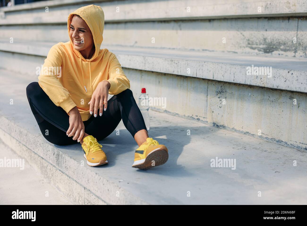 Cheerful woman in activewear resting on steps Stock Photo
