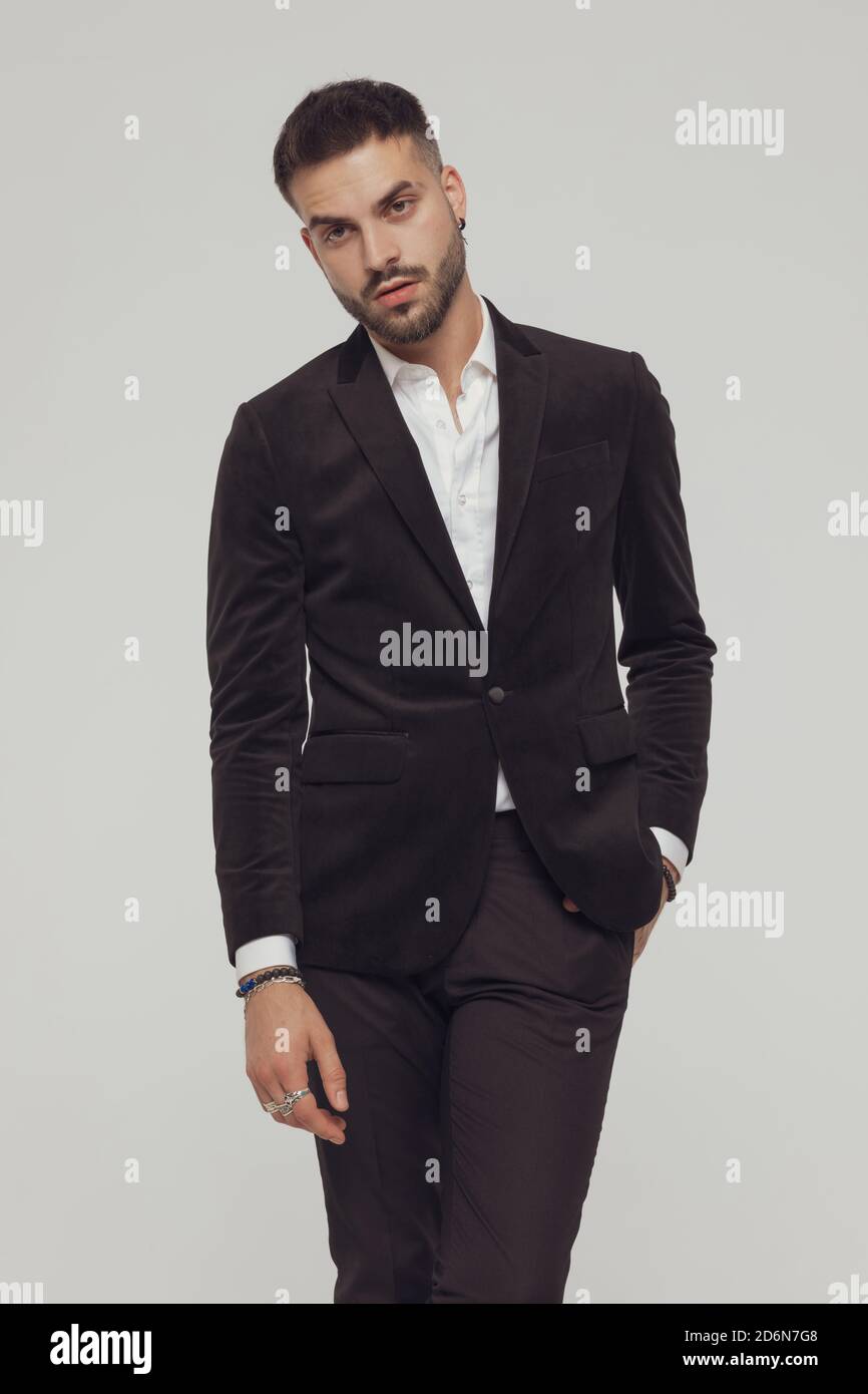 Charming Fashion Wearing Suit While Standing With Legs Crossed On Gray Studio Background Stock Photo Alamy alamy