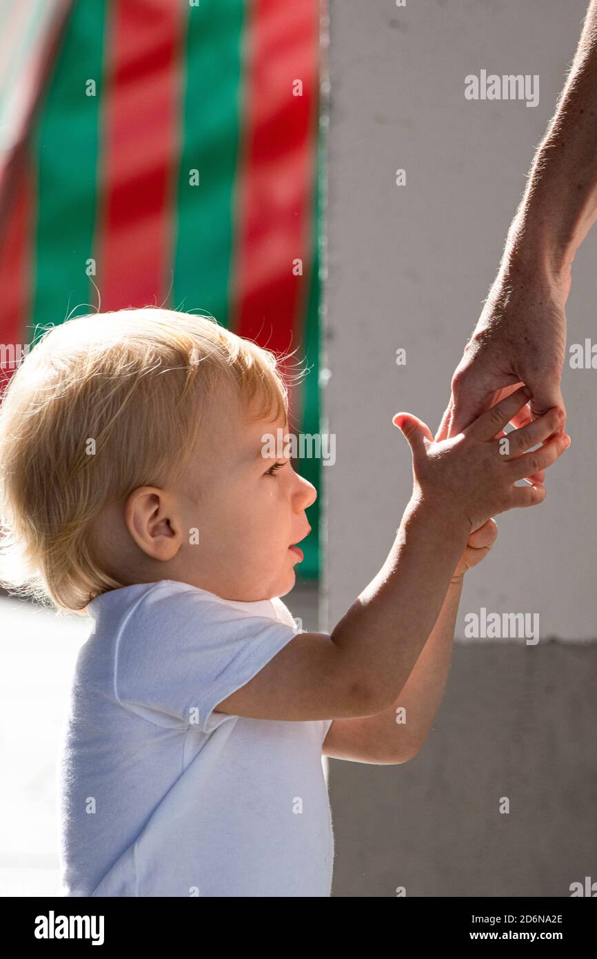 Young child looking for protection at the hands of his mother Stock Photo