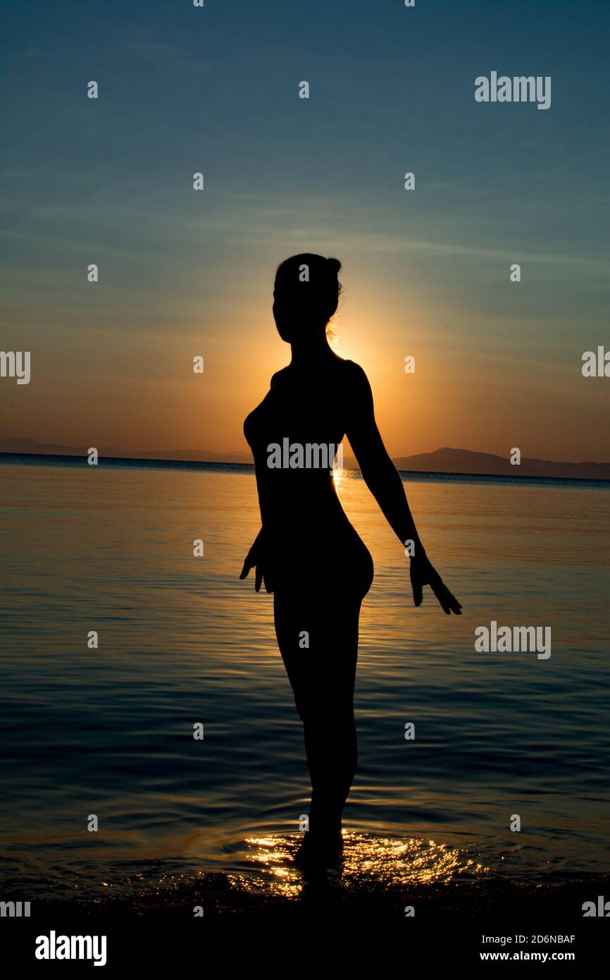 Beautiful Woman Sihlouette Standing in front of Sunset Stock Photo