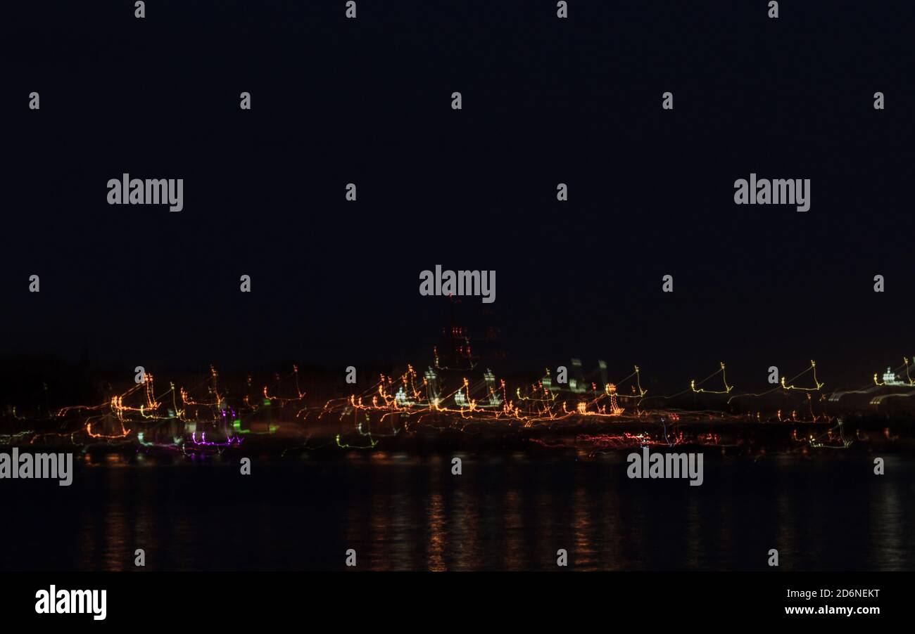 Night lights and lantern trails at dark night, city panorama view in blur. Colorful lights photograph art, abstract capital view. Stock Photo