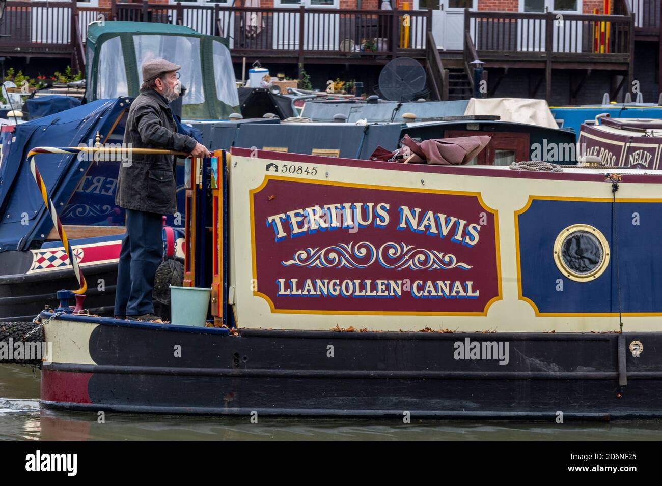 man at the helm or tiller of a traditional canal narrow boat ot barge on the grand union canal