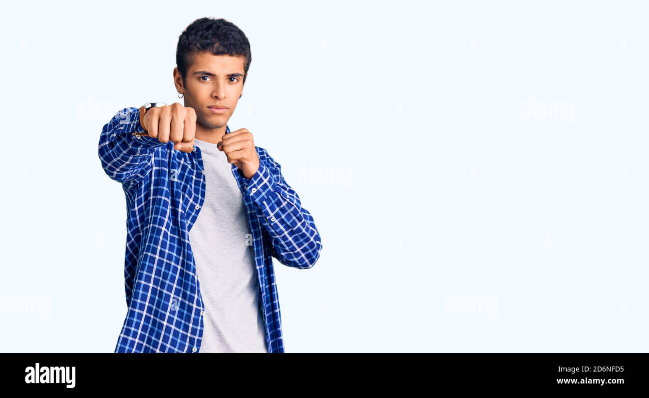 Young african amercian man wearing casual clothes punching fist to fight, aggressive and angry attack, threat and violence Stock Photo