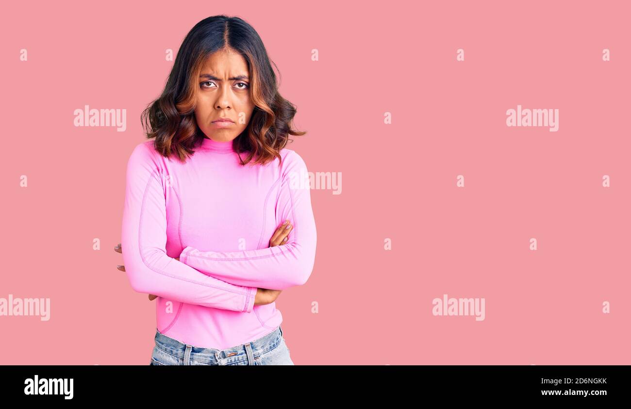 Young beautiful mixed race woman wearing pink shirt skeptic and