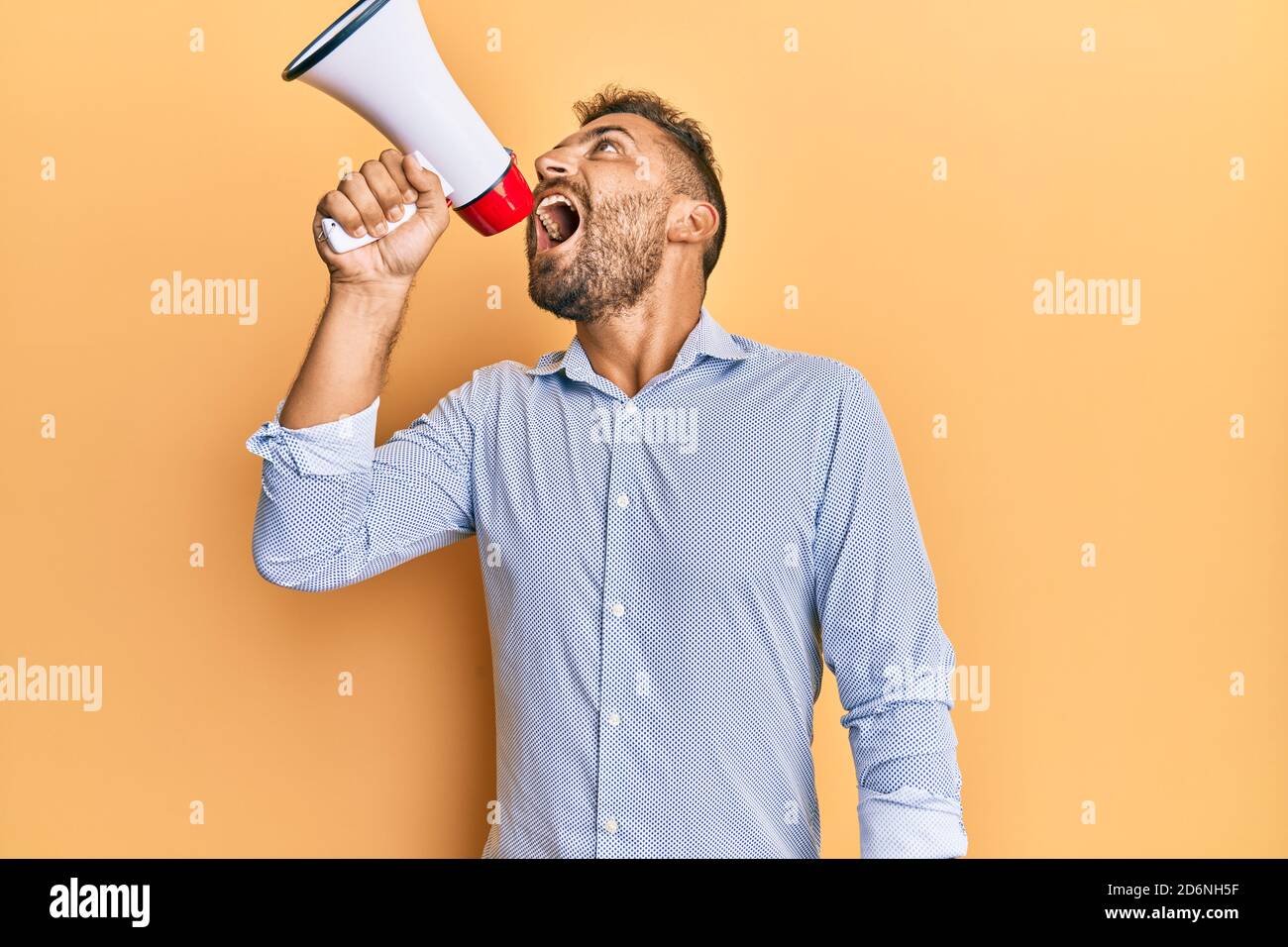 Shouting With Rage Handsome man with beard shouting through megaphone angry and mad ...