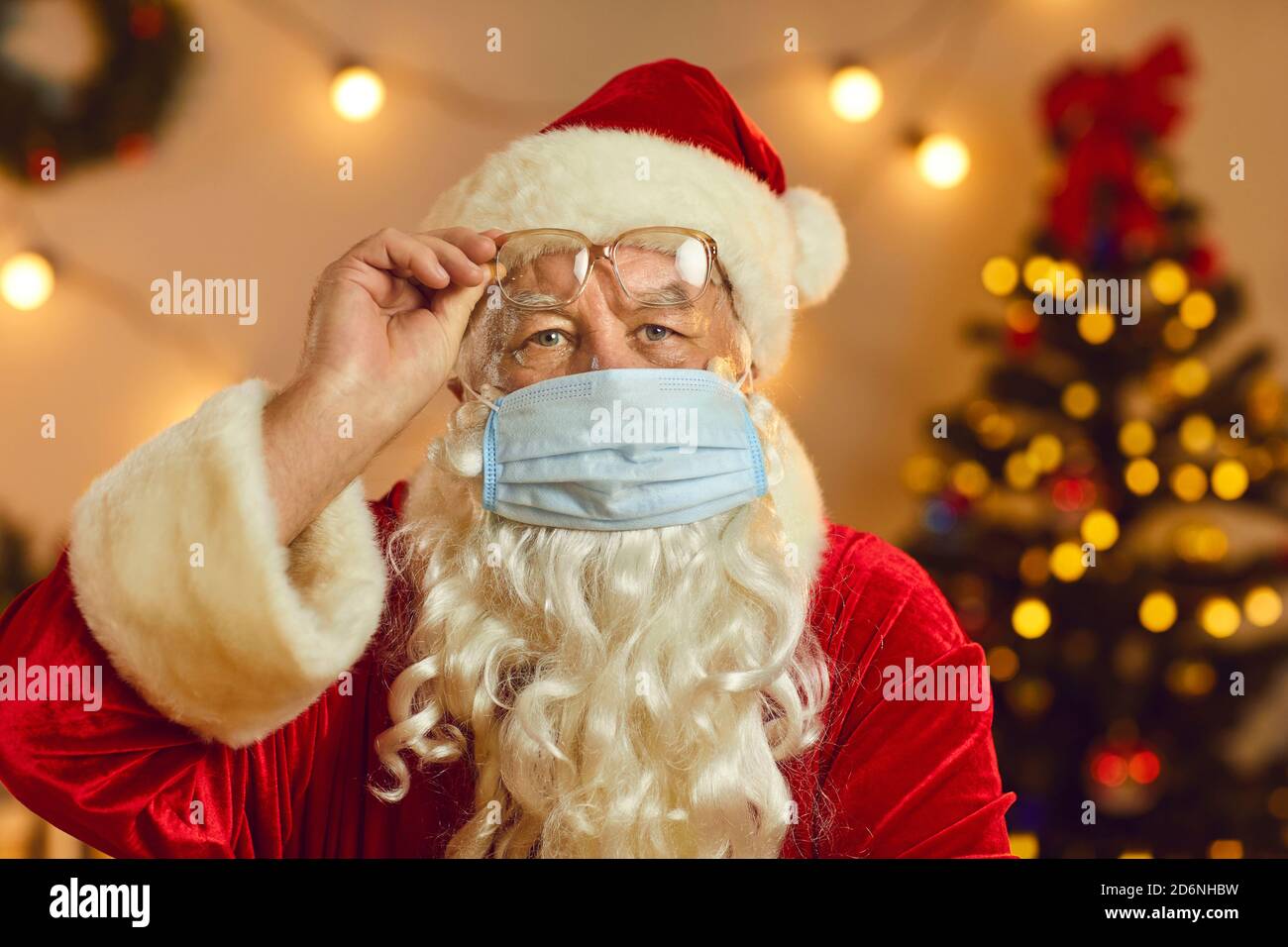 Santa in face mask warning about danger of covid infection and calling for self-isolation at home Stock Photo