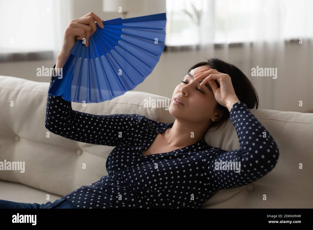 Unwell Asian woman use waver suffer from heatstroke Stock Photo