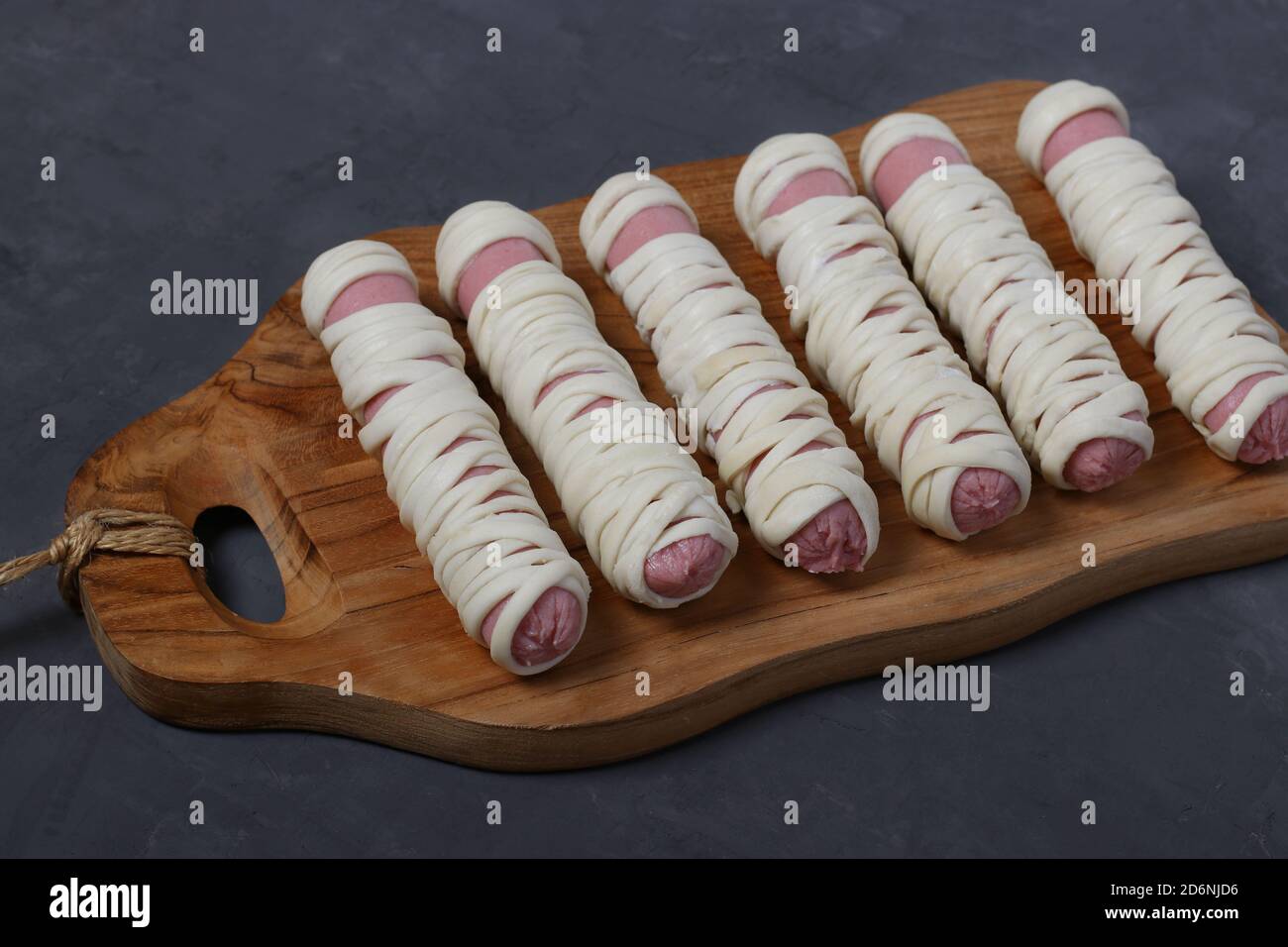 Sausage mummies in dough before baking. Food for Halloween on wooden ...