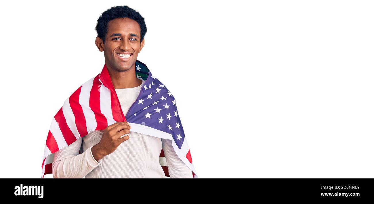 African handsome man holding united states flag looking positive and ...