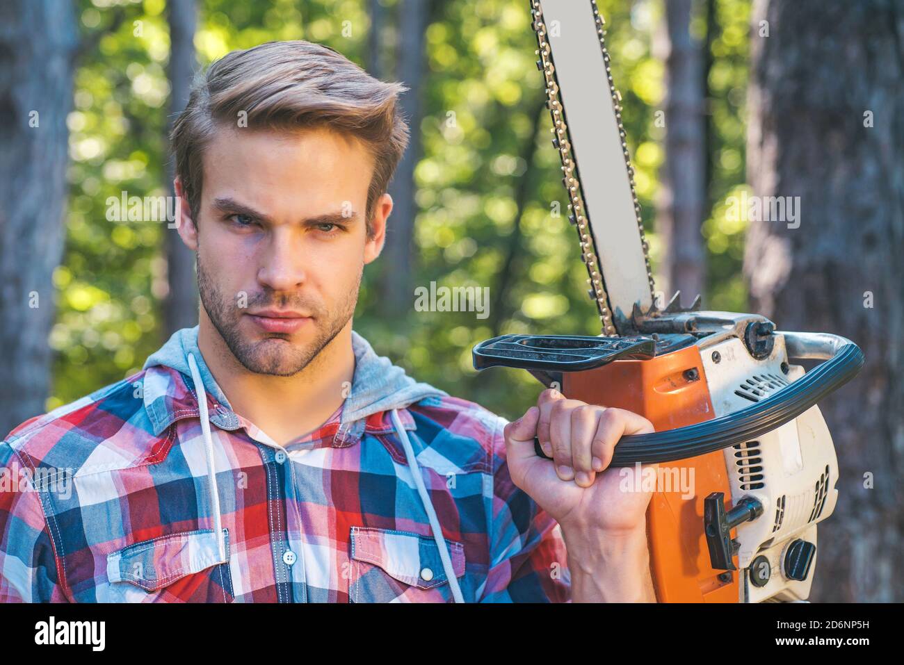 Lumberjack worker standing in the forest with chainsaw. Chainsaw