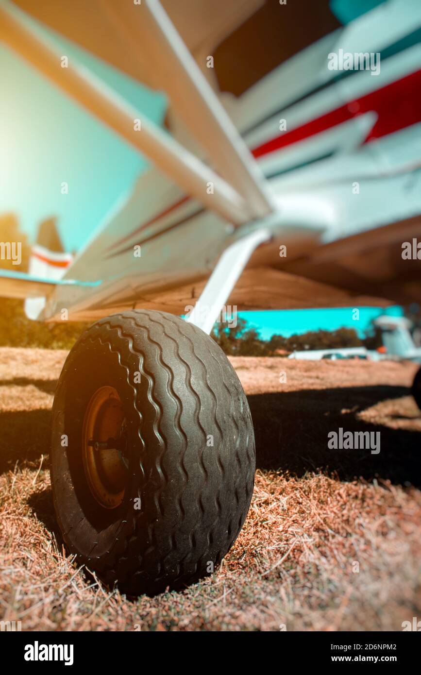 Small plane on grass runway wheel close-up Stock Photo