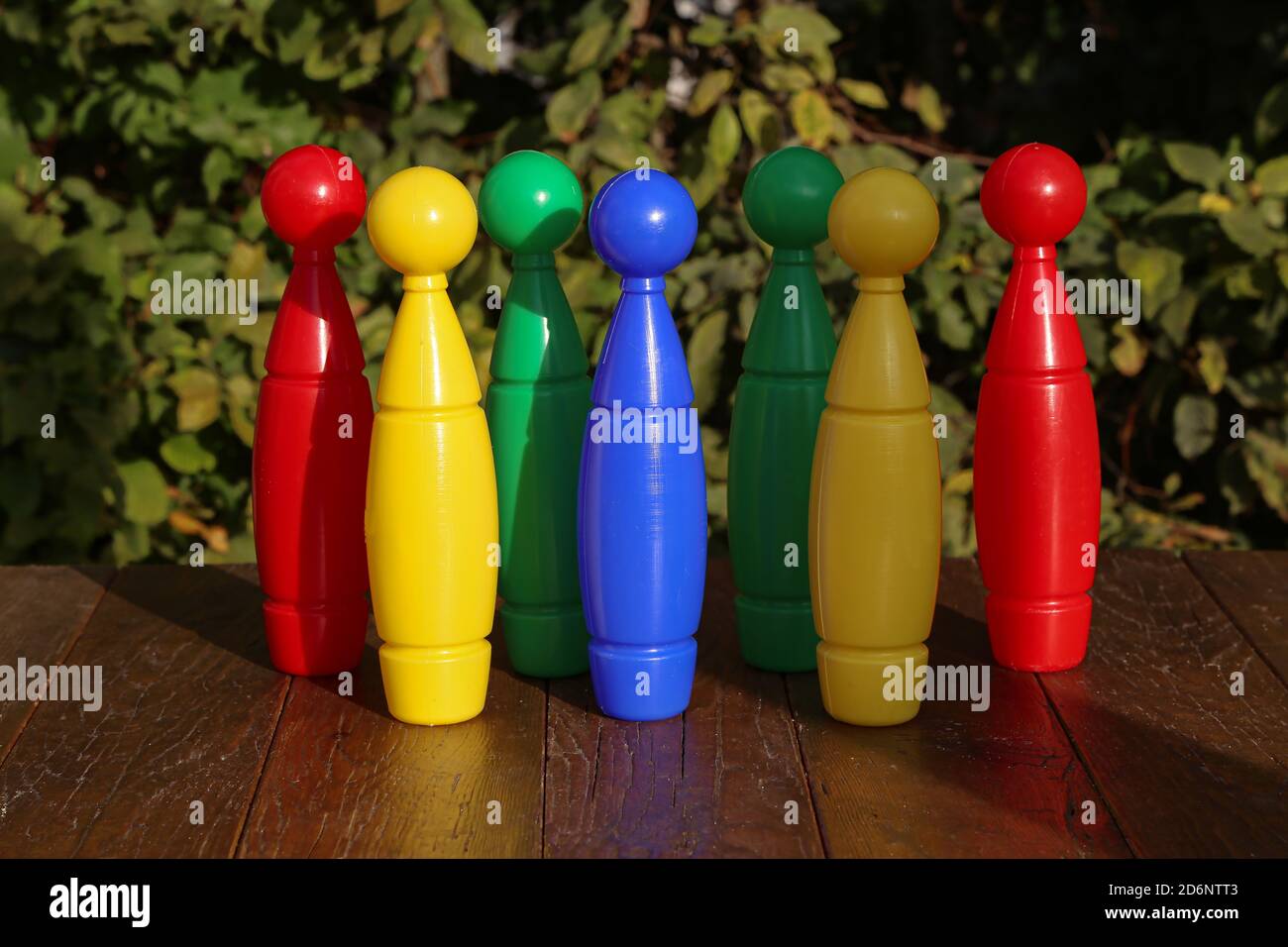Lot of colorful plastic toy bowling pins on a wooden surface Stock Photo