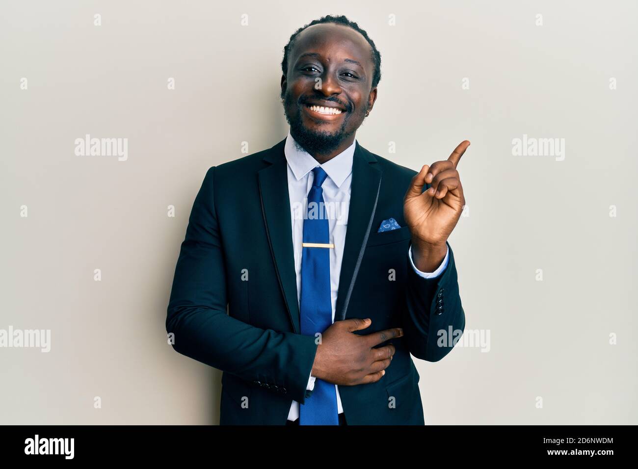 Handsome young black man wearing business suit and tie smiling happy ...