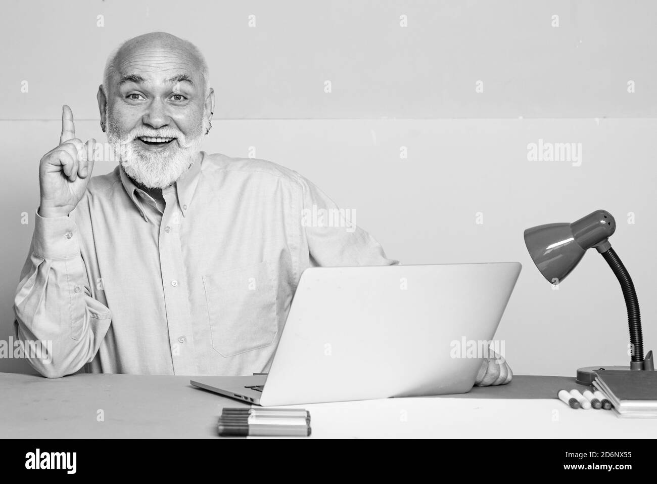 Old manager having friendly conversation at meeting with laptop. Senior business colleagues at meeting in office. Stock Photo