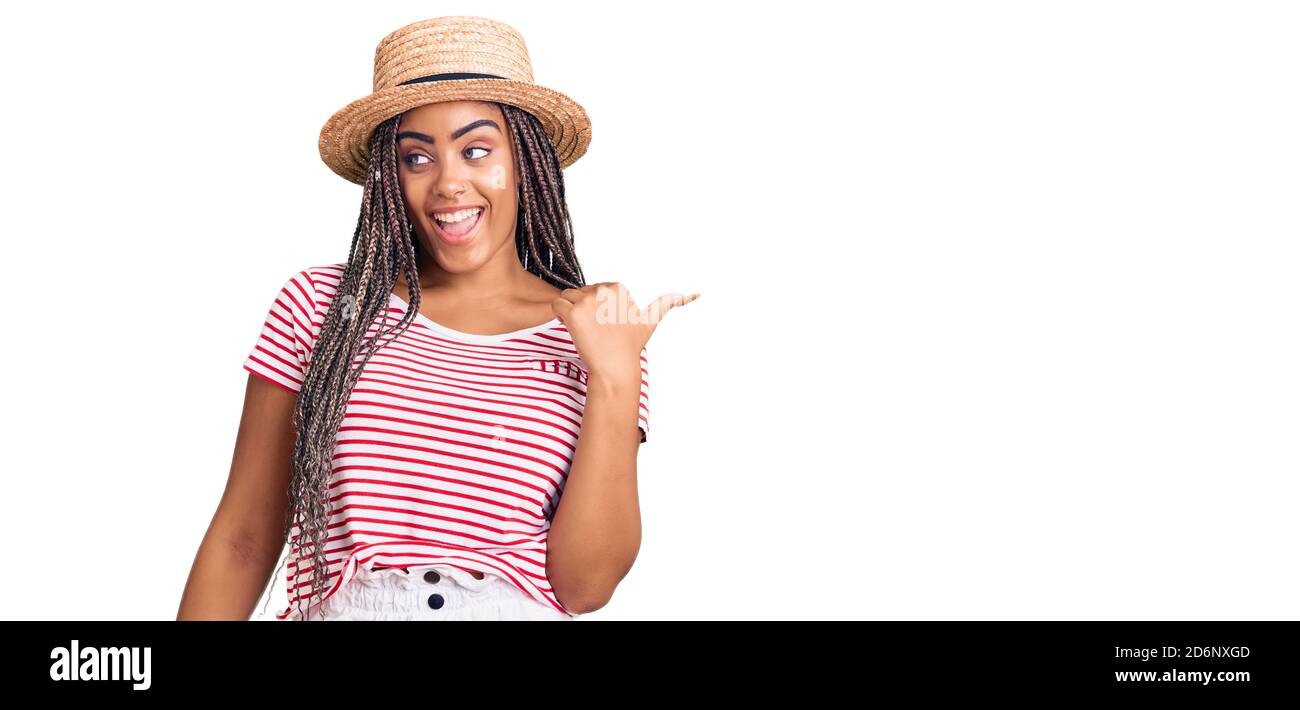 Young african american woman with braids wearing summer hat smiling ...