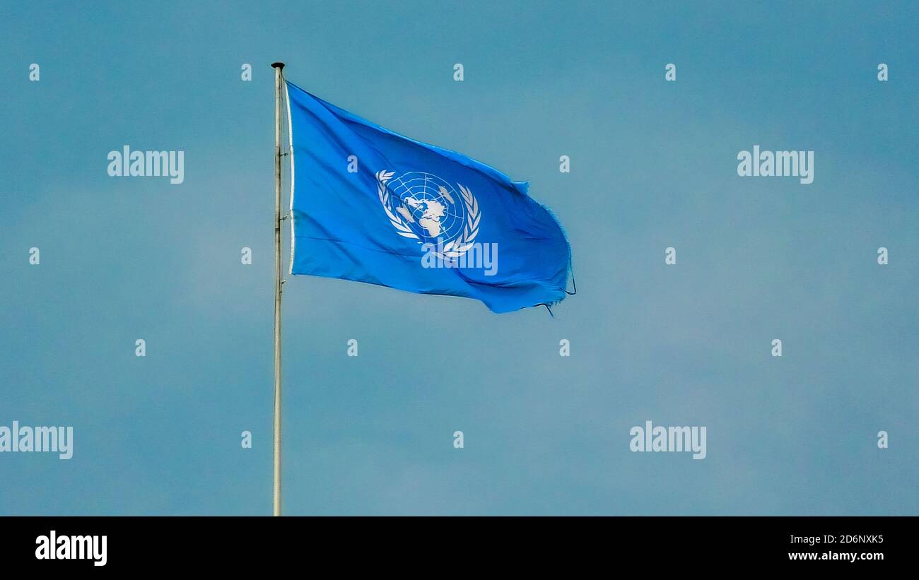 Geneva, Switzerland - Aug 16, 2020: flag with Emblem of United Nations building isolated against blue sky. European headquarters of UN. Stock Photo