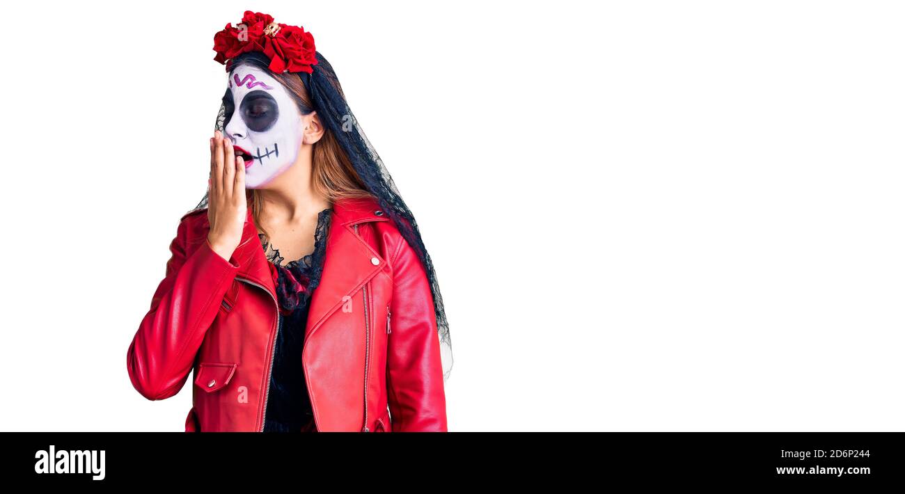 Woman wearing day of the dead costume over background bored yawning tired covering mouth with hand. restless and sleepiness. Stock Photo