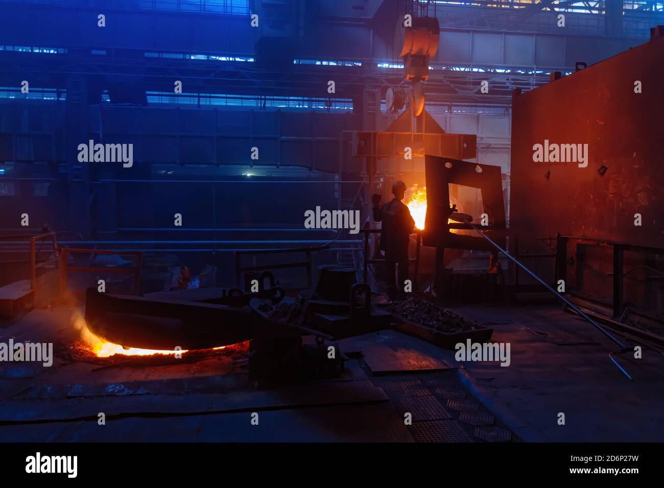 Worker operates metal casting process in metallurgical plant Stock Photo