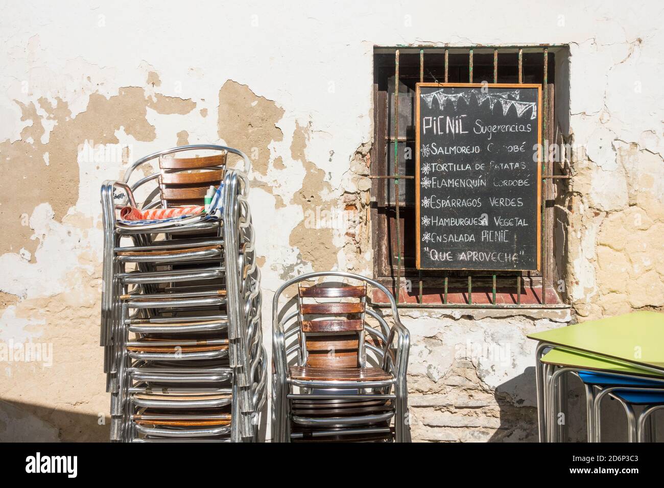 Stacked chairs at closed spanish restaurant due to restrictions in corona crisis, Tarifa, Spain. Stock Photo