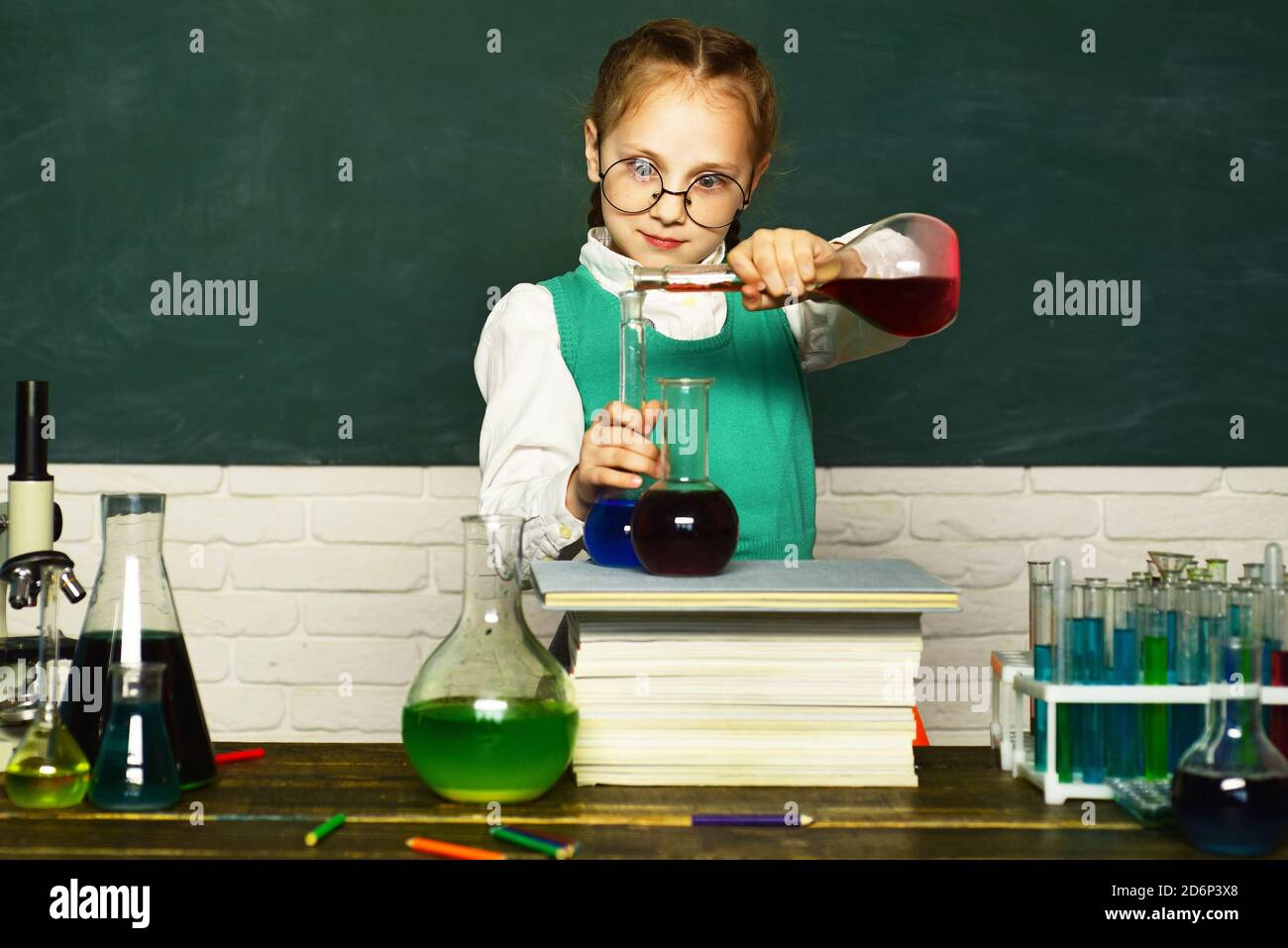 Lab microscope and testing tubes. Child in the class room with