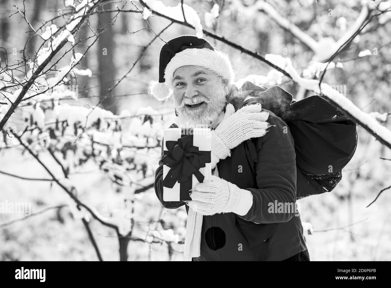 Santa on Christmas Eve is carrying presents to children in a red bag