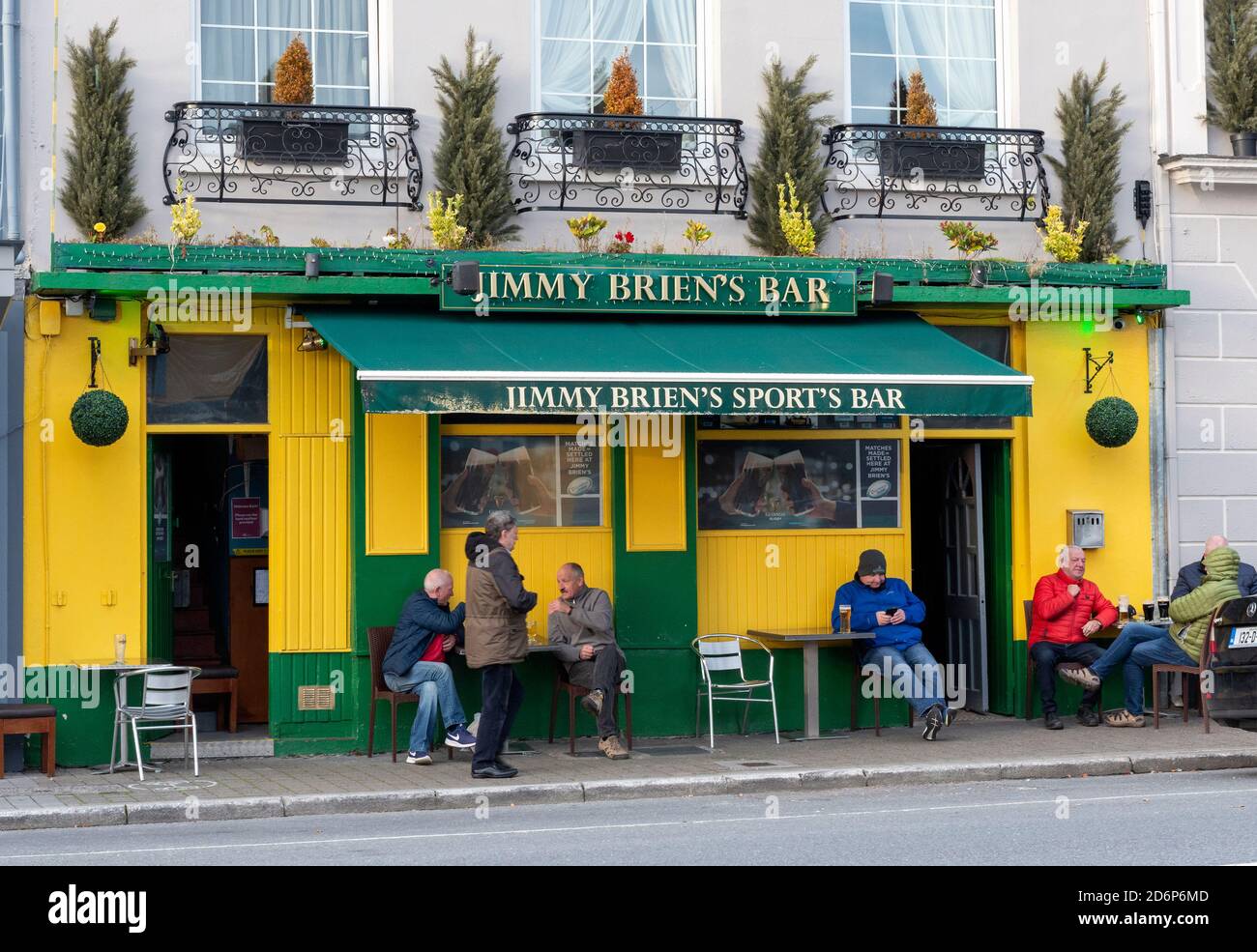 Men drinking and chatting while social distancing at outdoor tables outside Jimmy Brien's Bar in Killarney County Kerry Ireland Stock Photo