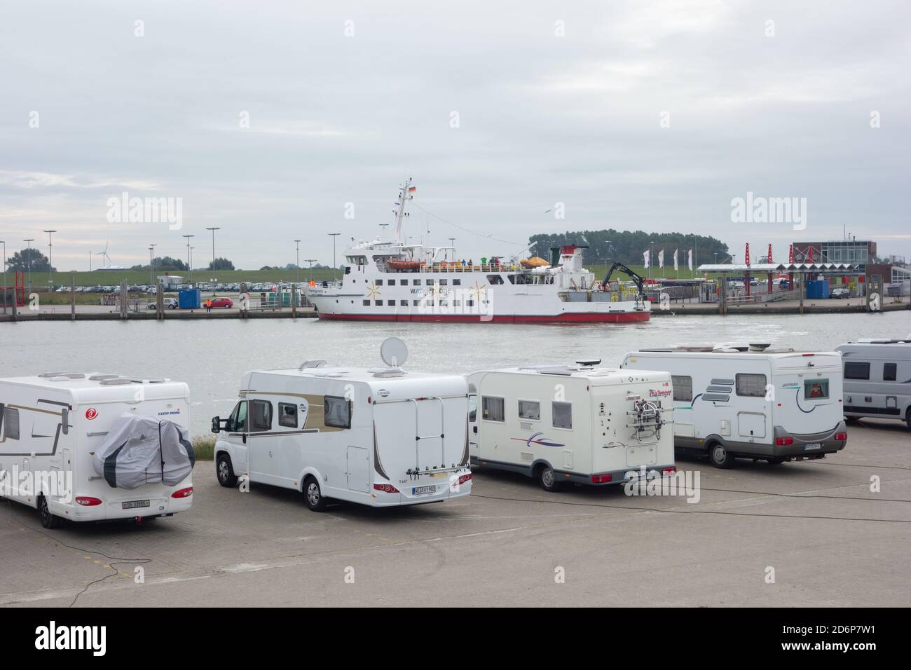 Ferry from the Fresian Islands arring in Neuharlingersiel harbour with motor homes parked in foreground. Lower Saxony. Germany. October 2020 Stock Photo