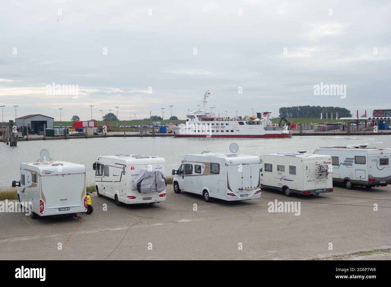 Ferry from the Fresian Islands arring in Neuharlingersiel harbour with motor homes parked in foreground. Lower Saxony. Germany. October 2020 Stock Photo