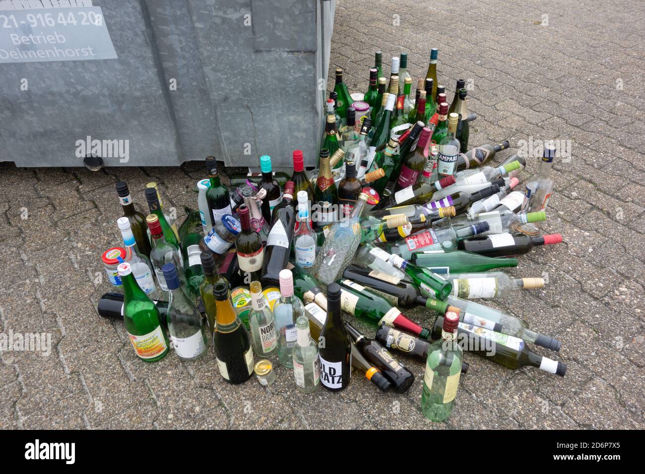 Large pile of glass drinks bottles left by public bin for recycling Lower Saxony. Germany. Stock Photo
