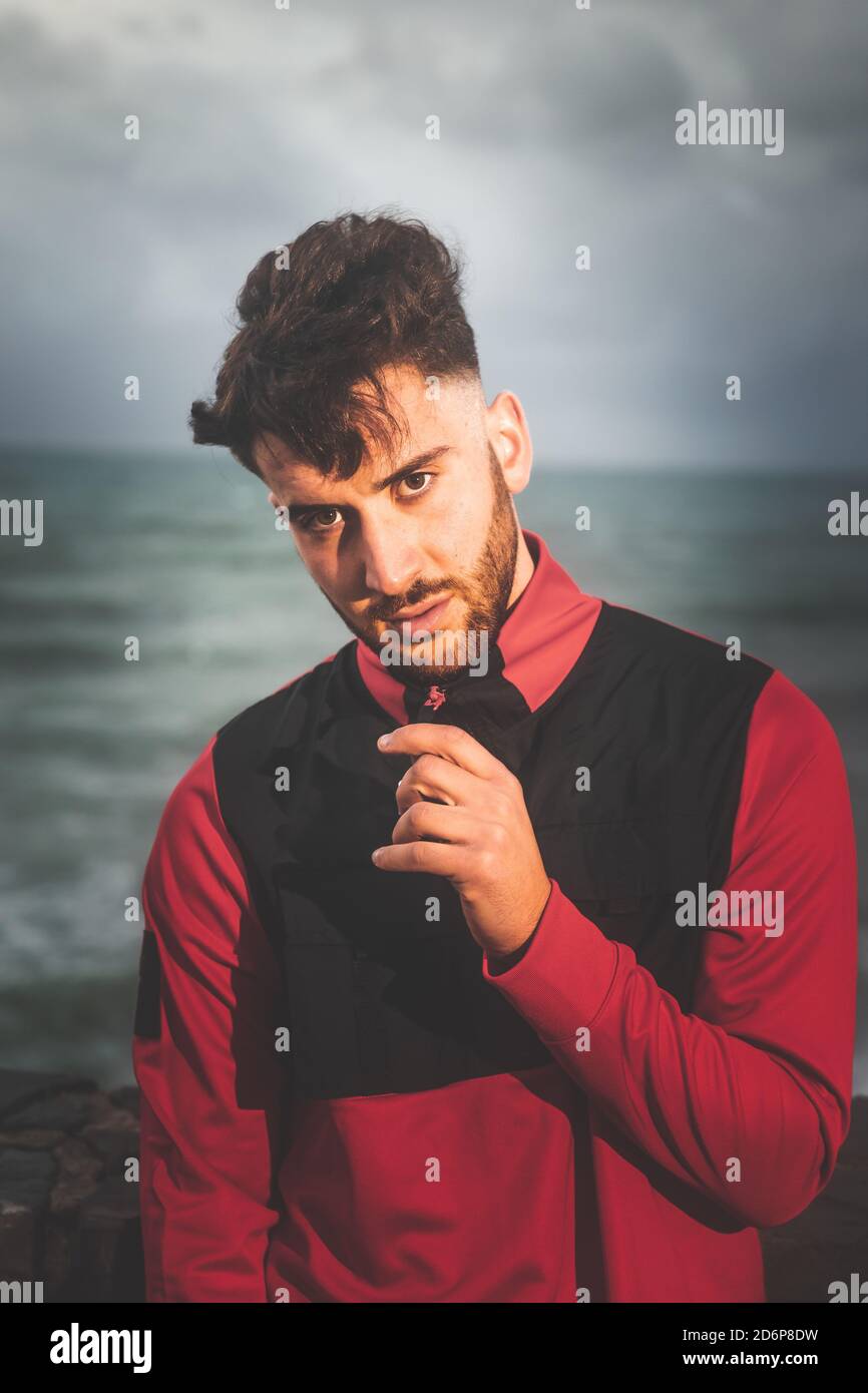 Young caucasian man posing at a sea port. Stock Photo