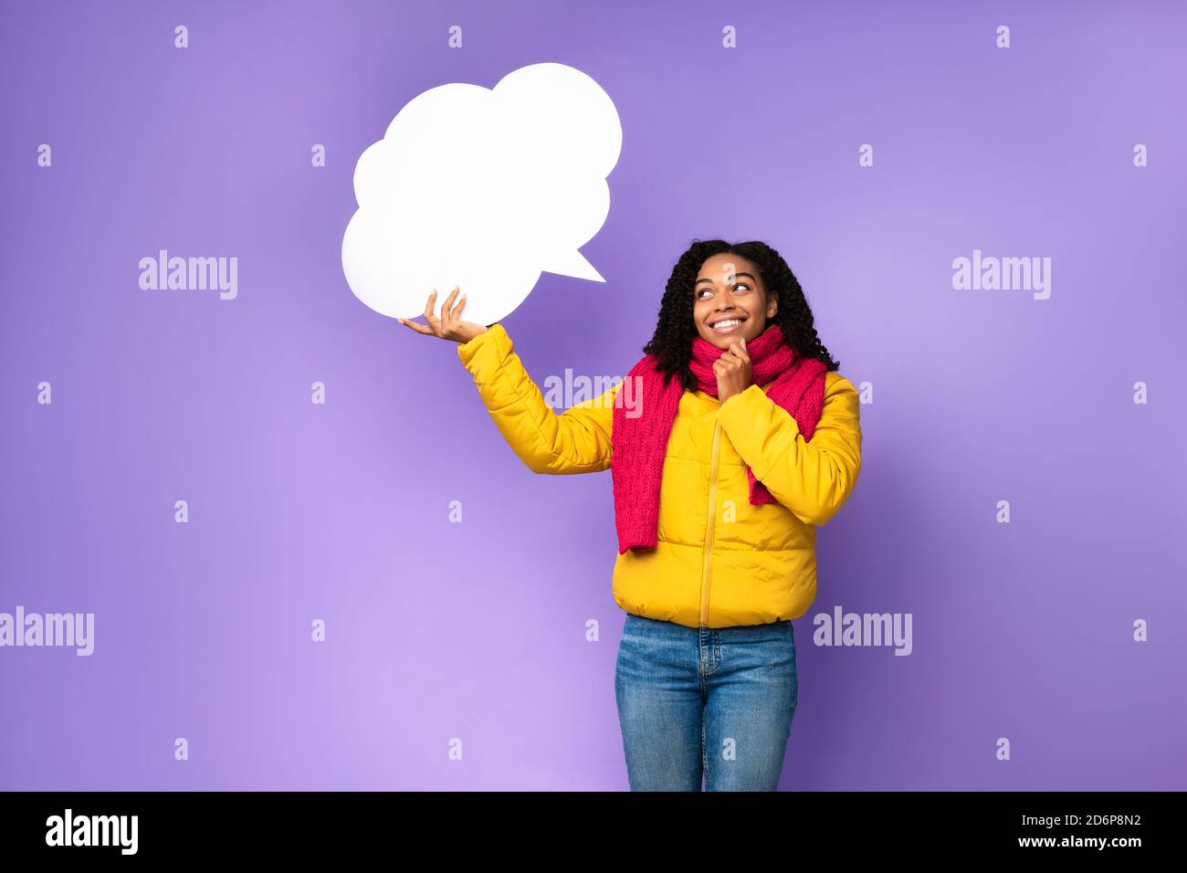Black Woman Holding Empty Speech Bubble Above Head, Purple Background Stock Photo