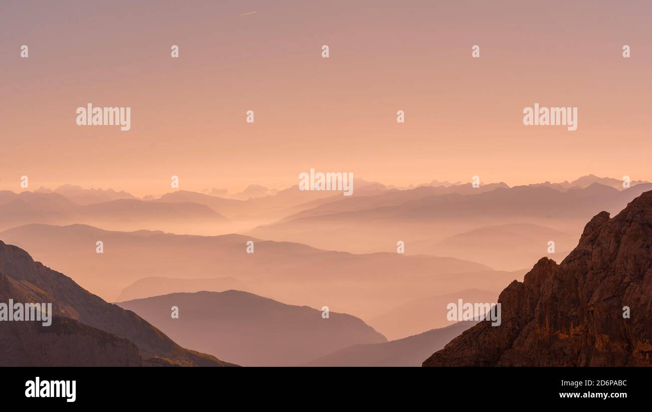 fog at sunrise over the mountain ranges of the dolomites in italy Stock ...