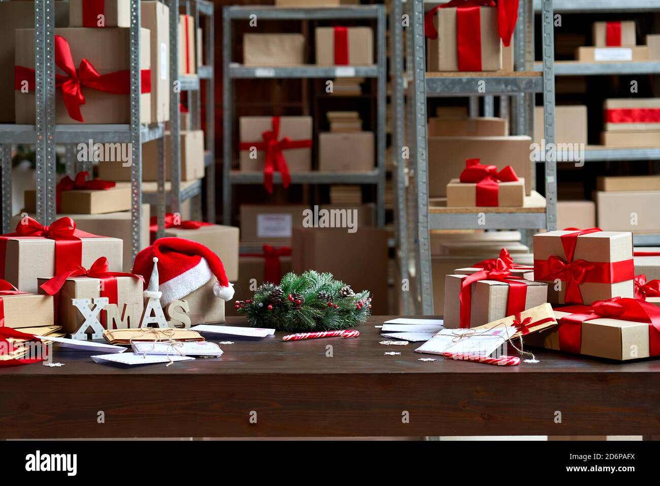 Decorated Christmas table with gifts boxes in warehouse interior background. Stock Photo