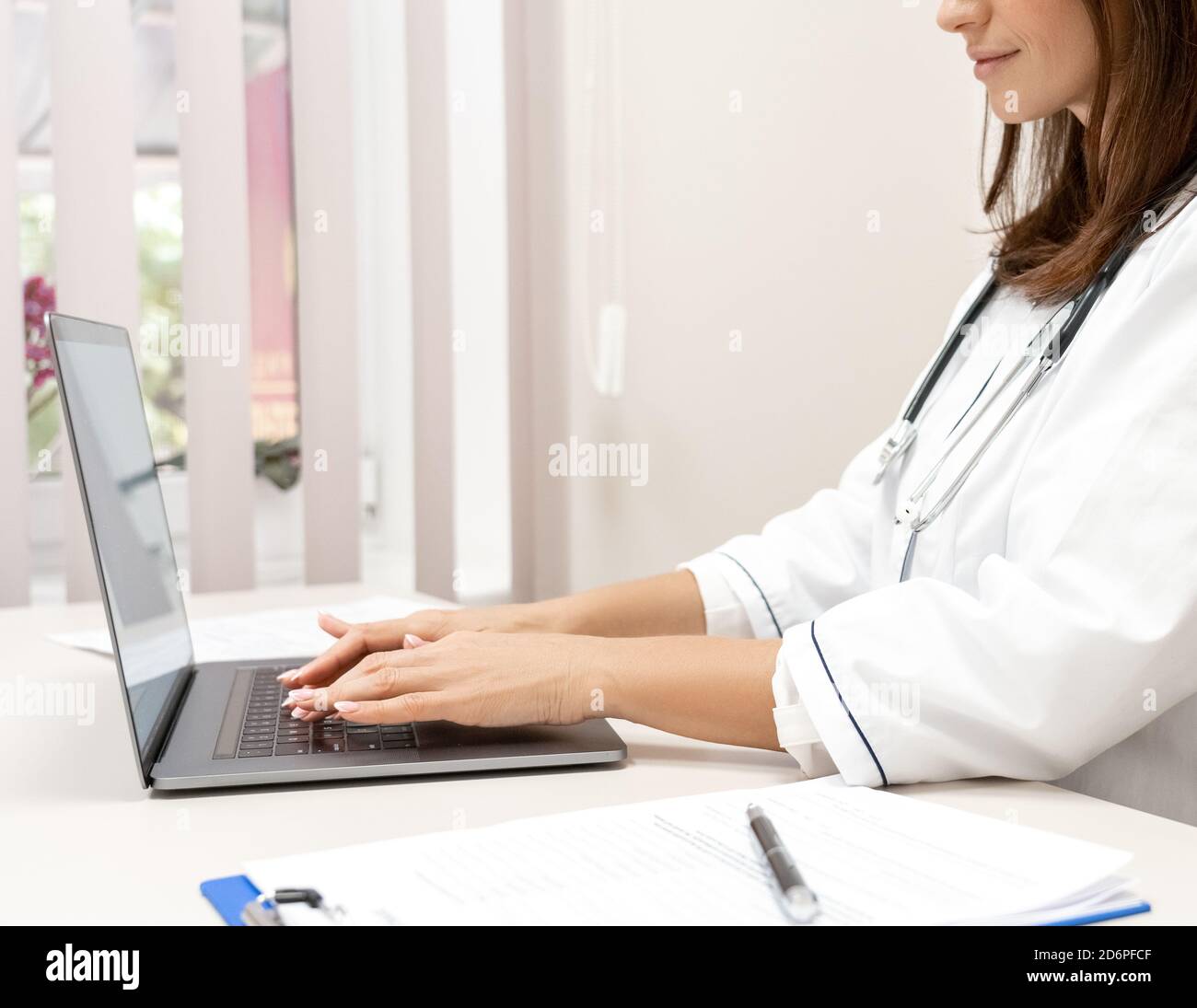 Close-up view on female doctor using laptop computer. Stock Photo