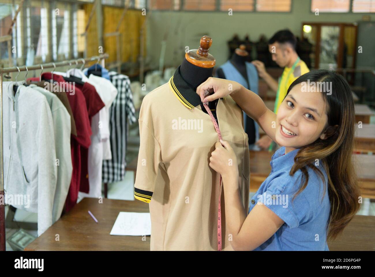 https://c8.alamy.com/comp/2D6PG4P/beautiful-tailor-women-smiling-when-measure-the-mannequin-chest-width-with-tape-measure-at-the-clothing-garment-room-2D6PG4P.jpg