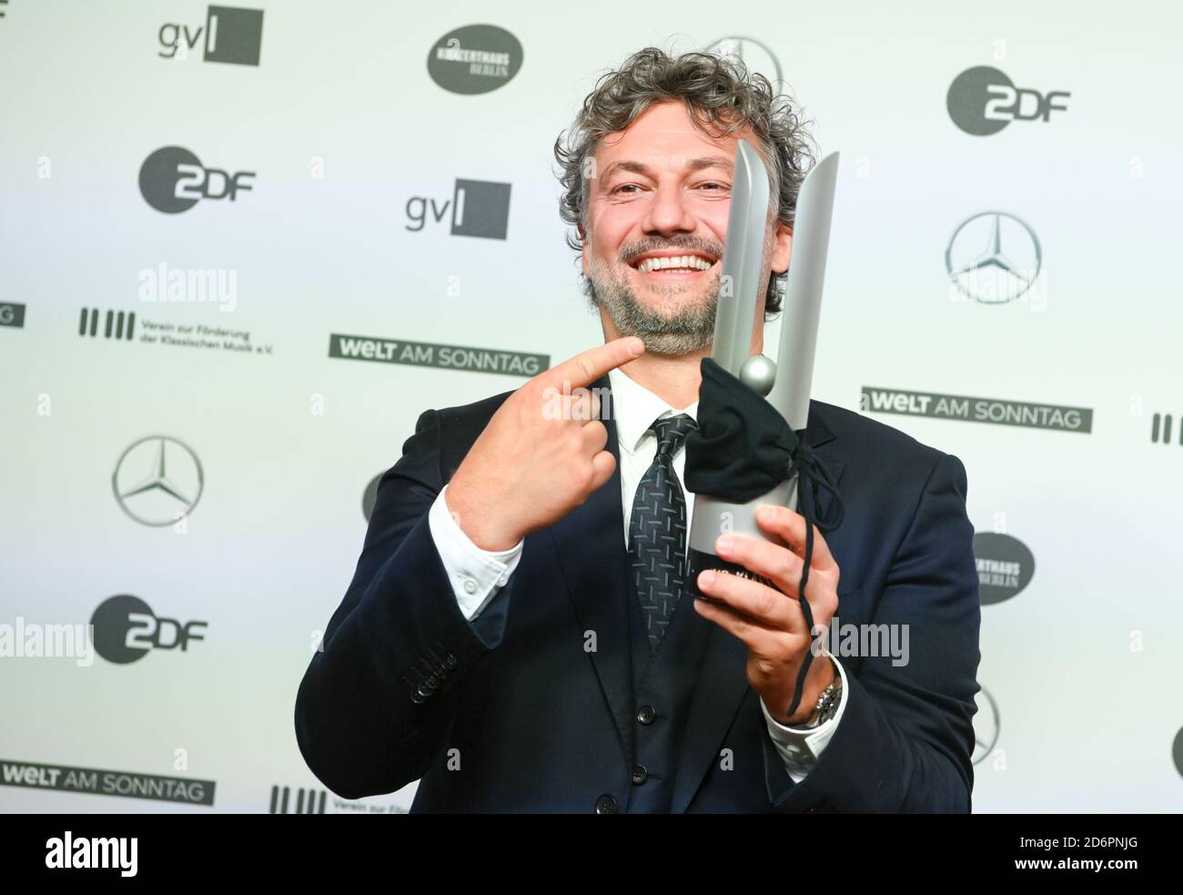Berlin, Germany. 18th Oct, 2020. The opera singer Jonas Kaufmann will present his prize at the Opus Klassik 2020 music award ceremony at the Konzerthaus am Gendarmenmarkt. He received the prize for his album 'Vienna' in the category 'Classical without Borders' and has tied his mouth and nose protection around it. Since 2018, music companies, record labels and concert organizers have been awarding the prize to 47 winners in 25 categories. Credit: Jens Kalaene/dpa-Zentralbild/dpa/Alamy Live News Stock Photo
