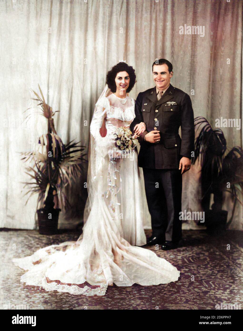 1946 ca, BRESCIA , ITALY : The marriage of BETTY & CHARLIE , she was from the North italian Brescia town and he from UNITED STATES of AMERICA during the military service just after the Worlld War 2nd in Italy . The couple traferred immediately in U.S. . Unknown photographer . DIGITALLY COLORIZED . - NOZZE - abito da SPOSA - WEDDING dress PARTY - BRIDE -  cerimonia   - FOTO STORICHE - HISTORY PHOTOS - XX CENTURY - NOVECENTO  - coppia di sposi - military uniform - uniforme vestito militare - thulle - tulle - strascico  - FAMIGLIA - FAMILY - marito e moglie - wife and husband - festa - party - ri Stock Photo