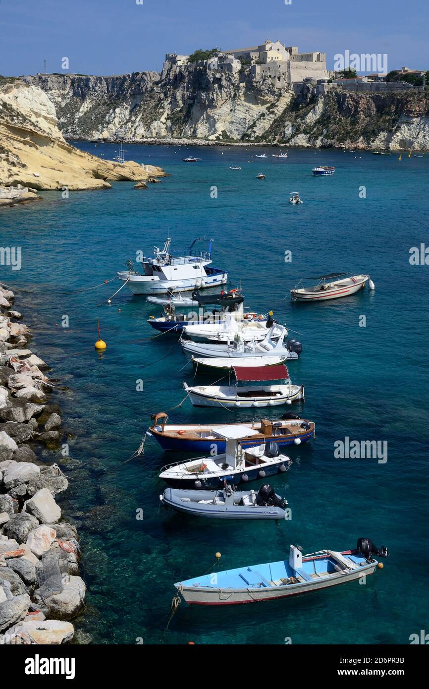 a stretch of Tremiti archipelago with some boats moored in San Domino port  and the fortress of San Nicola island in background Stock Photo - Alamy