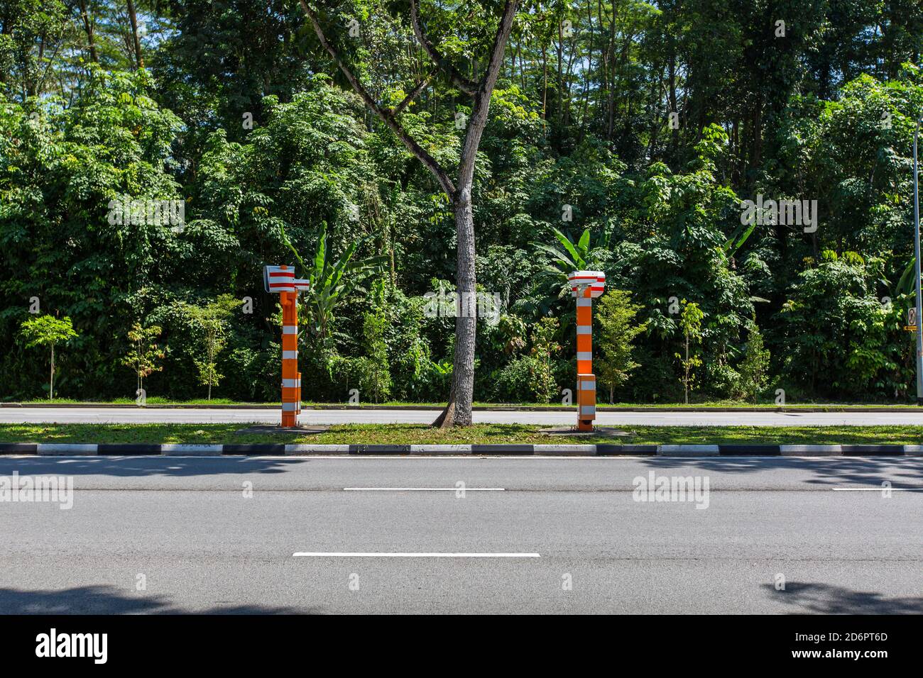Orange and white colour police fixed speed camera (FSC) fixed on the divider of the road to discourage drivers from speeding up from afar. Stock Photo