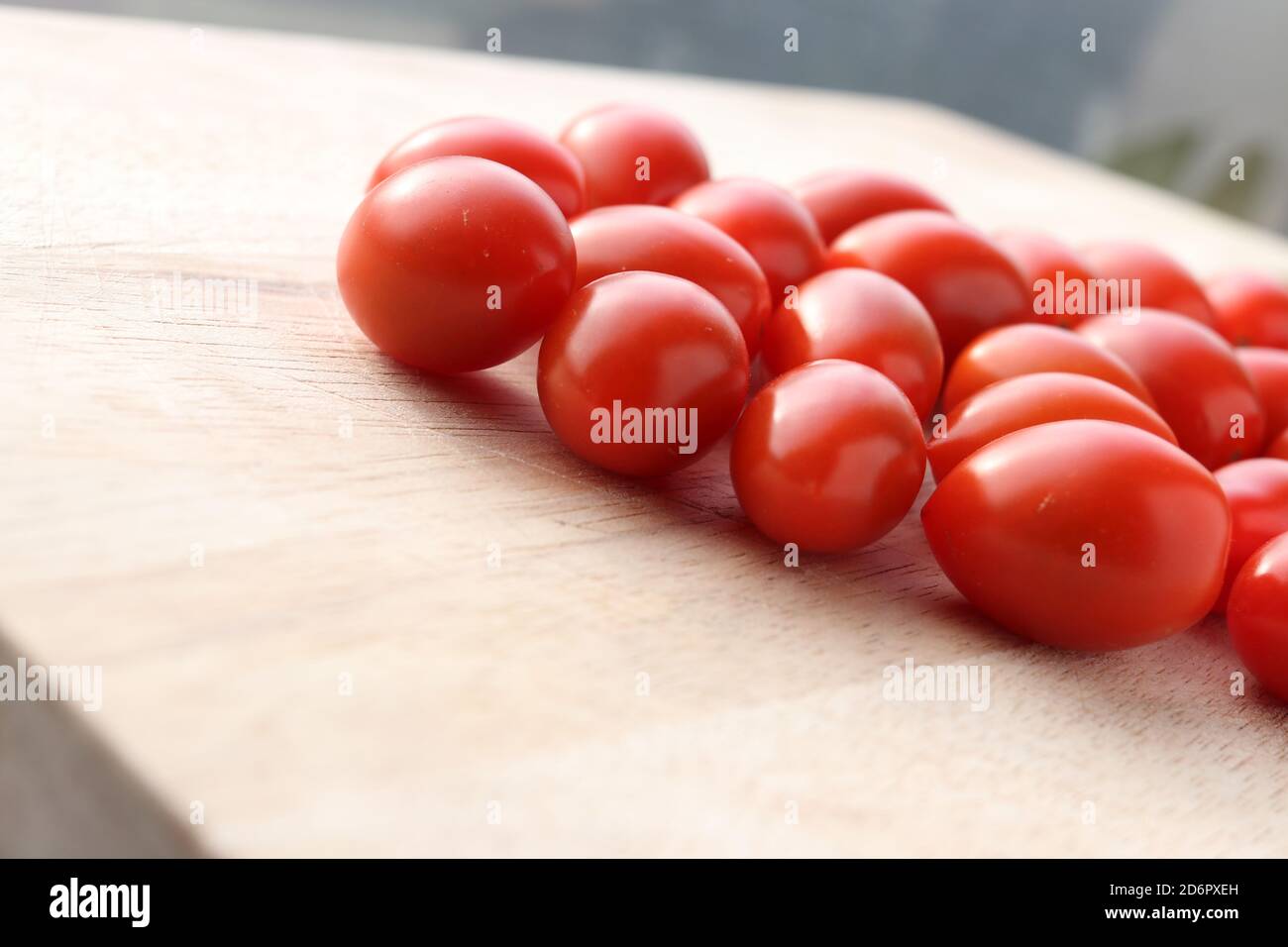 cherry tomatoes on a wooden chopping board Stock Photo - Alamy