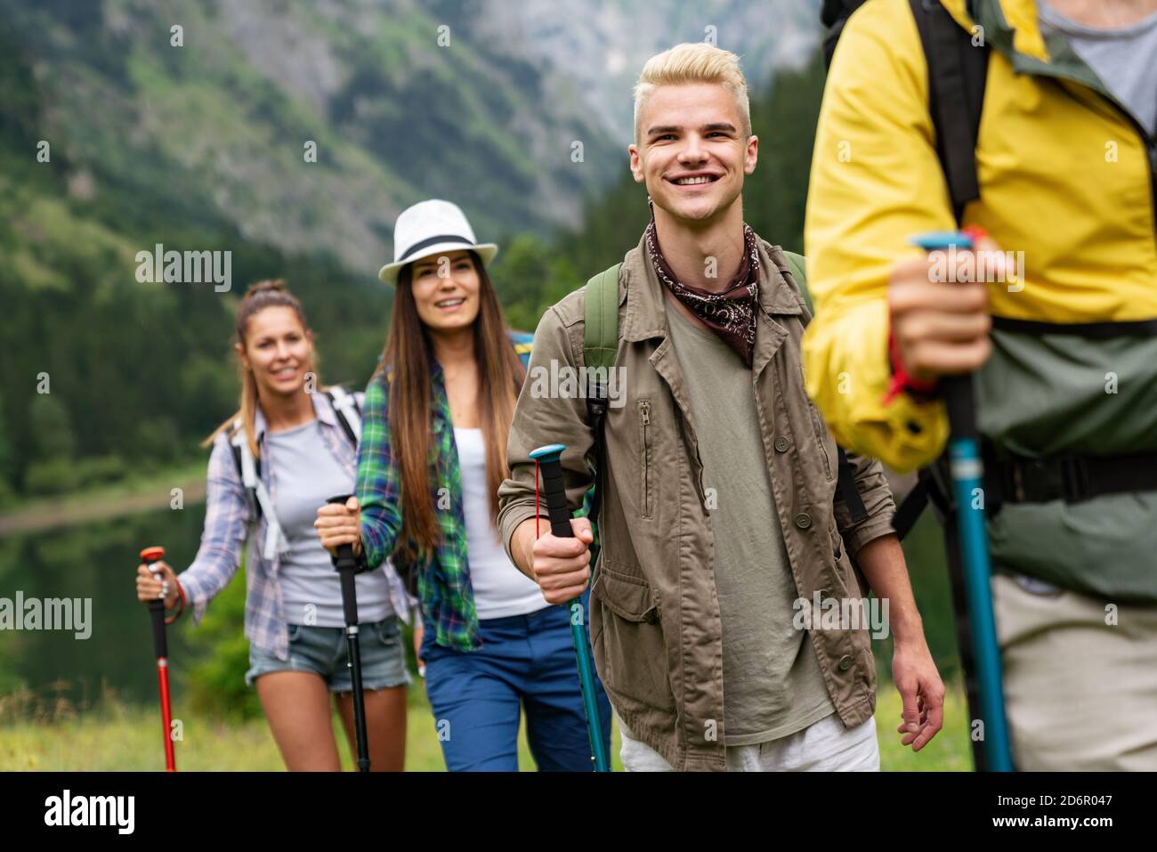 Group of young friends hiking in countryside. Multiracial happy people ...