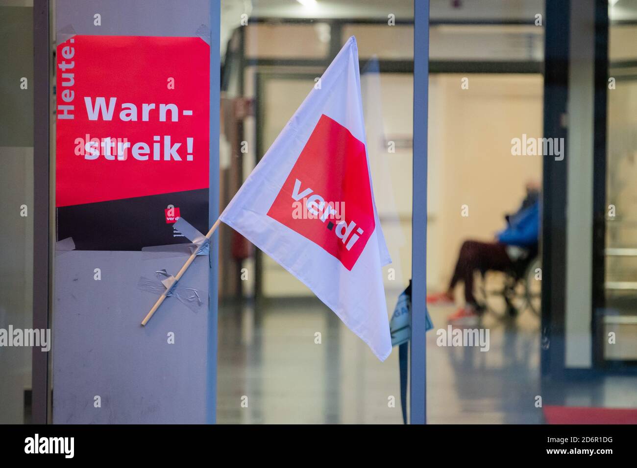 Berlin, Germany. 19th Oct, 2020. A Verdi flag as well as a poster are hanging in front of a wheelchair user during a strike by employees of the Berlin Charite hospital at the high-rise bed block. The early shift starts on Monday (19.10.2020) at Vivantes and at the Charite with a two-day strike, which is to be ended on Tuesday at the end of the late shift. Credit: Christoph Soeder/dpa/Alamy Live News Stock Photo