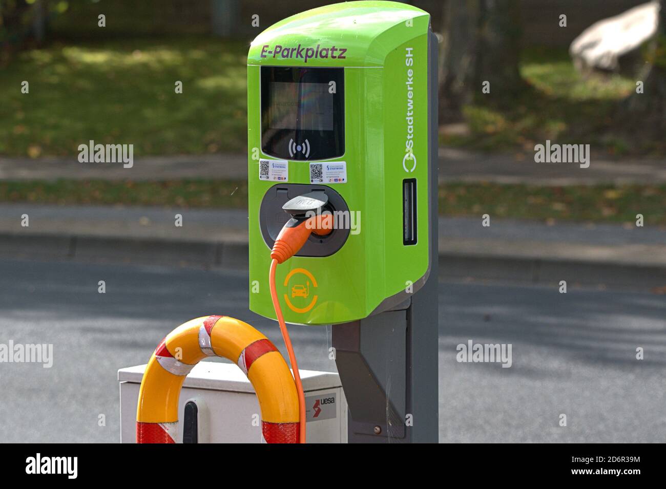 October 17, 2020, a green charging station from Stadtwerke SH on a parking lot in Friedrich-Ebert-Strasse in Schleswig Two vehicles can be charged at the same time at this charging station. An orange charging plug is plugged into a socket to charge an e-car. | usage worldwide Stock Photo