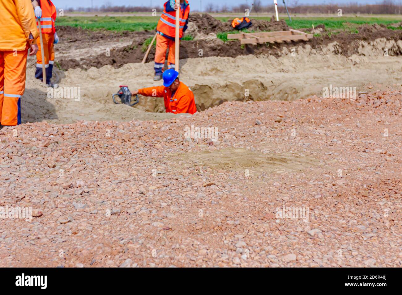 Worker is compacting gravel using vibration plate compactor machine in