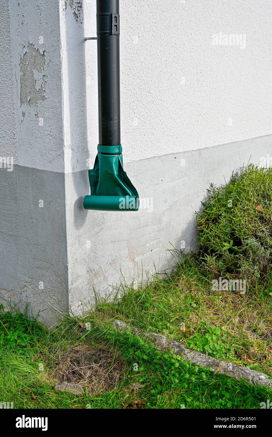 metal downpipe with plastic outomatic roll at house Stock Photo