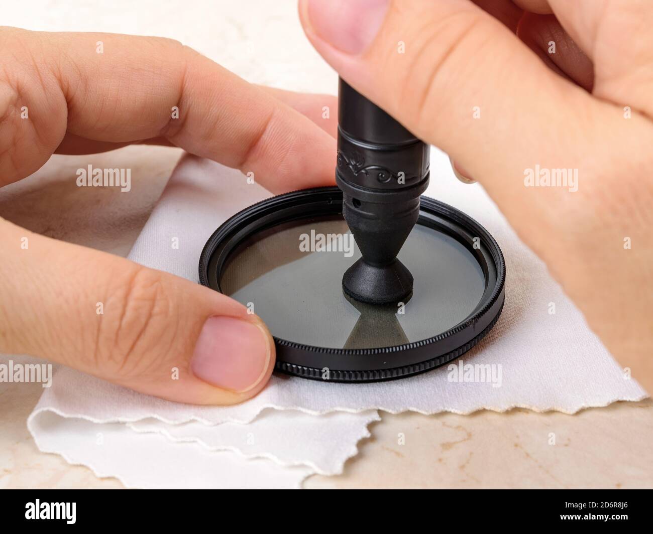 Hands polish camera polarizing filter using lens pen soft felt end over