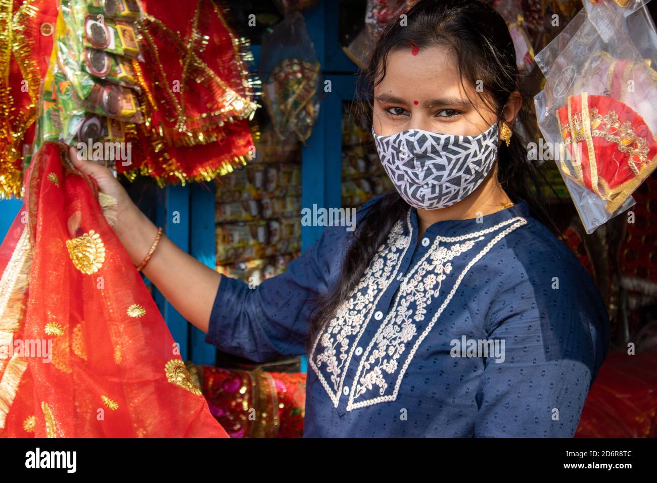 A Beautiful Indian lady wearing face mask is shopping for the Navratri festival in India. High quality photo Stock Photo