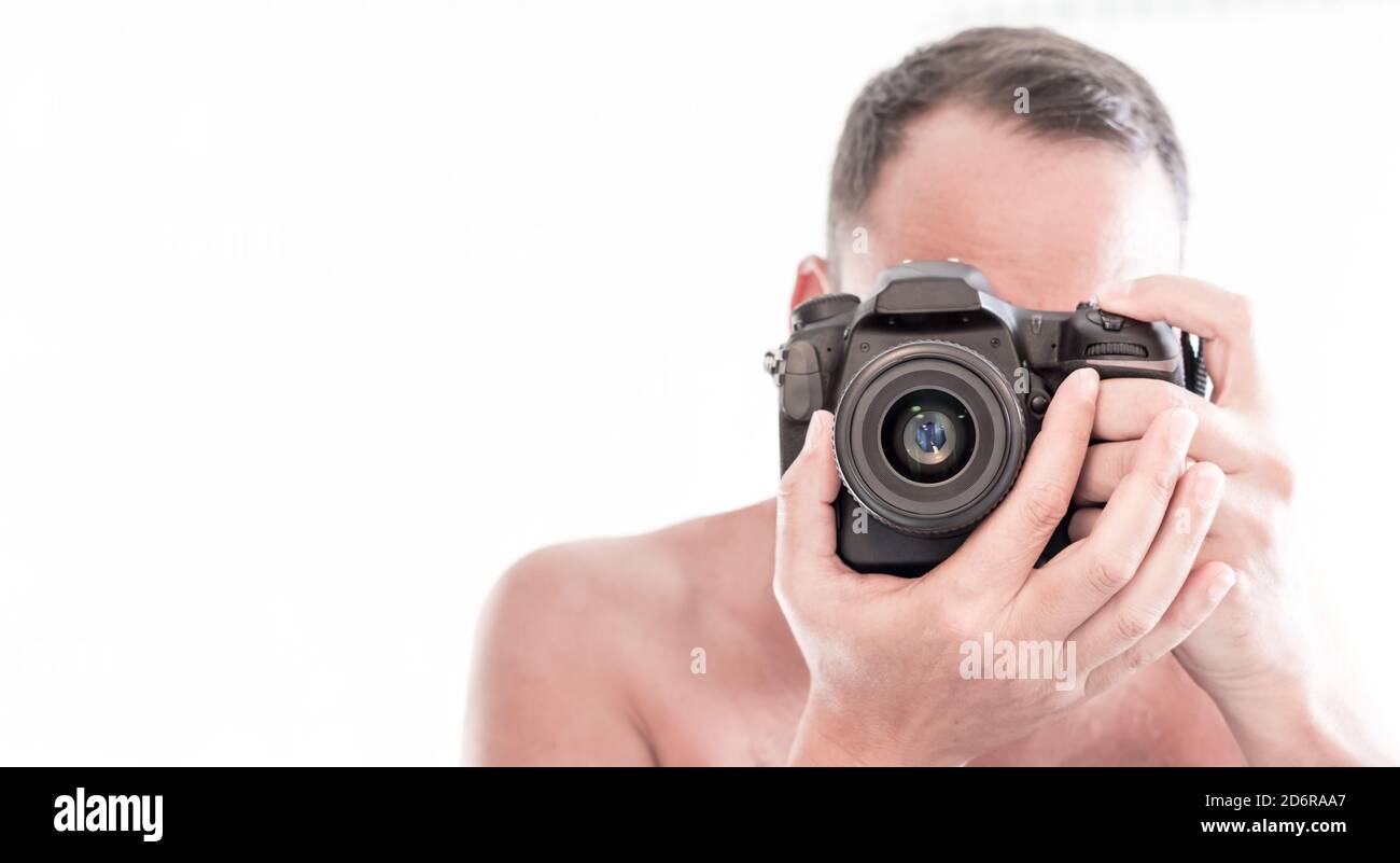 closeup of a young man focusing and looking through the viewfinder of his reflex camera taking a picture. copy space Stock Photo